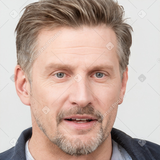 Joyful white adult male with short  brown hair and grey eyes