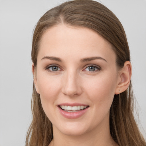 Joyful white young-adult female with long  brown hair and grey eyes