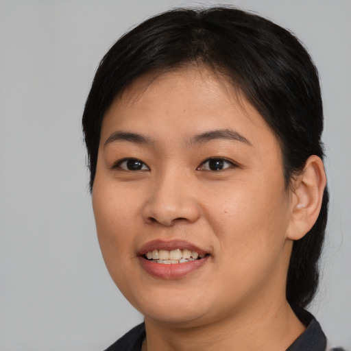 Joyful asian young-adult female with medium  black hair and brown eyes