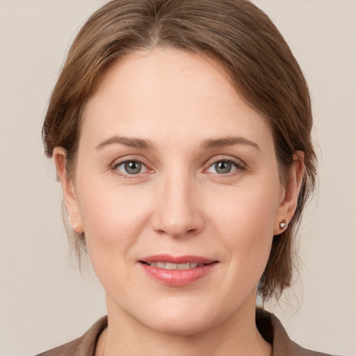 Joyful white young-adult female with medium  brown hair and grey eyes