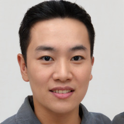 Joyful asian young-adult male with short  black hair and brown eyes