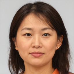 Joyful asian young-adult female with medium  brown hair and brown eyes