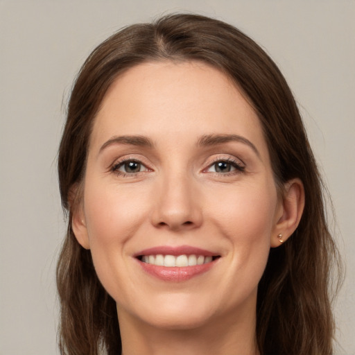 Joyful white young-adult female with long  brown hair and grey eyes