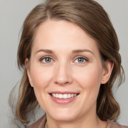 Joyful white young-adult female with medium  brown hair and grey eyes