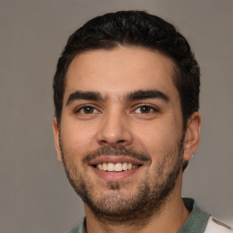 Joyful white young-adult male with short  black hair and brown eyes