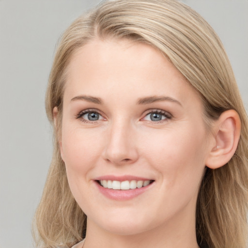 Joyful white young-adult female with long  brown hair and blue eyes