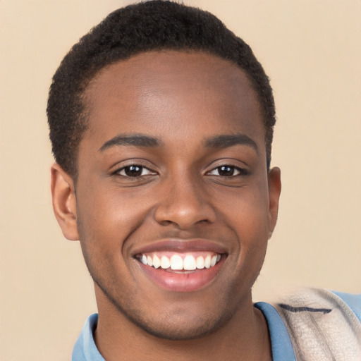 Joyful black young-adult male with short  brown hair and brown eyes