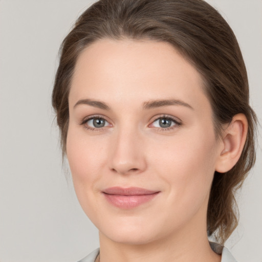 Joyful white young-adult female with medium  brown hair and grey eyes