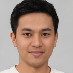 Joyful latino young-adult male with short  brown hair and brown eyes