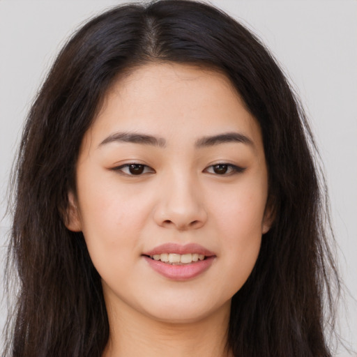 Joyful asian young-adult female with long  brown hair and brown eyes
