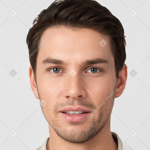 Joyful white young-adult male with short  brown hair and grey eyes