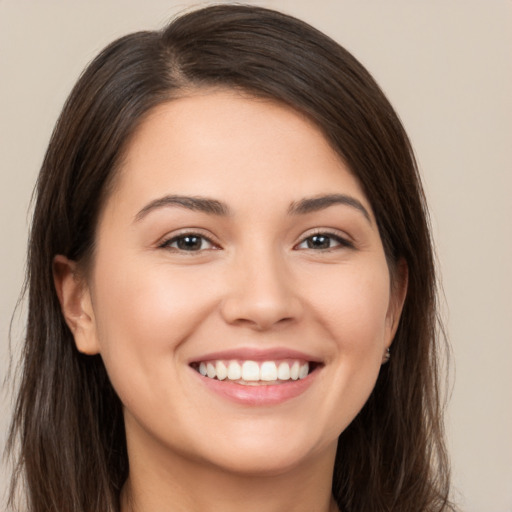 Joyful white young-adult female with long  brown hair and brown eyes