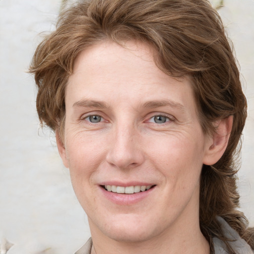 Joyful white adult female with medium  brown hair and grey eyes