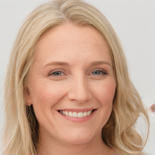 Joyful white young-adult female with long  blond hair and blue eyes