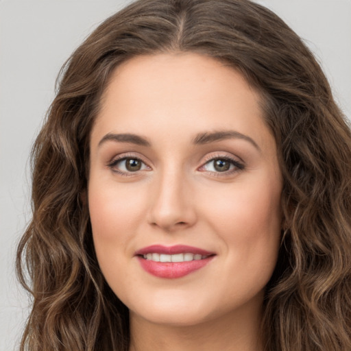 Joyful white young-adult female with long  brown hair and green eyes