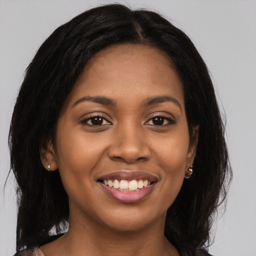 Joyful black young-adult female with long  brown hair and brown eyes