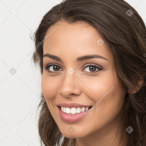 Joyful white young-adult female with long  brown hair and brown eyes