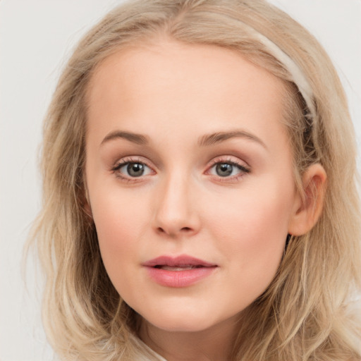 Joyful white young-adult female with long  brown hair and blue eyes