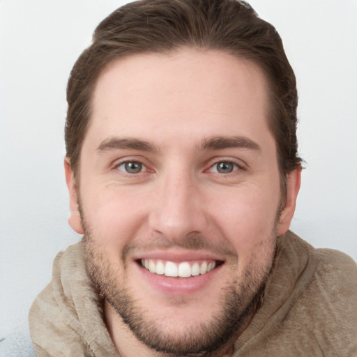 Joyful white young-adult male with short  brown hair and grey eyes