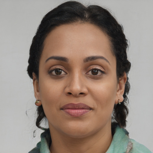 Joyful black young-adult female with long  brown hair and brown eyes