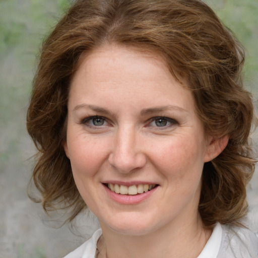 Joyful white young-adult female with medium  brown hair and green eyes