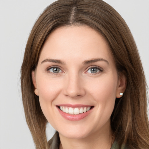 Joyful white young-adult female with long  brown hair and green eyes