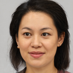 Joyful white adult female with medium  brown hair and brown eyes