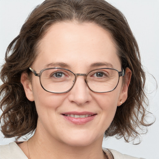 Joyful white adult female with medium  brown hair and blue eyes