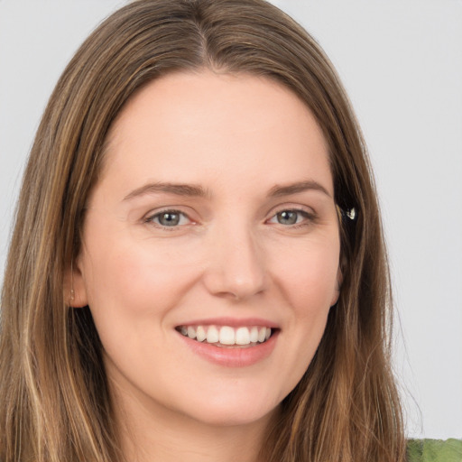 Joyful white young-adult female with long  brown hair and grey eyes