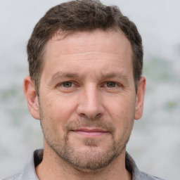 Joyful white adult male with short  brown hair and grey eyes