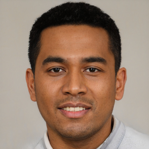 Joyful latino young-adult male with short  black hair and brown eyes