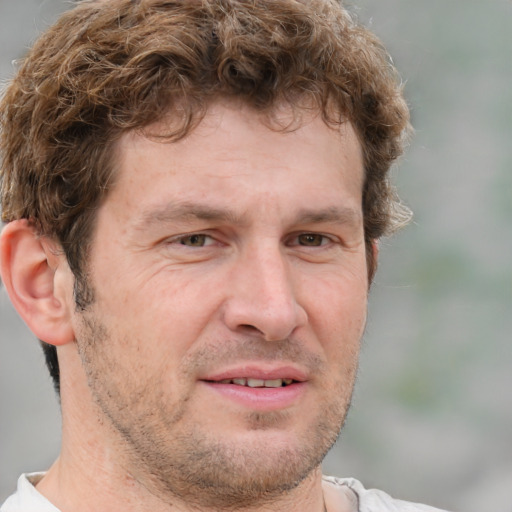 Joyful white adult male with short  brown hair and grey eyes