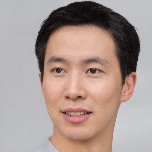 Joyful asian young-adult male with short  black hair and brown eyes