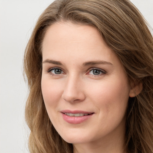 Joyful white young-adult female with long  brown hair and grey eyes