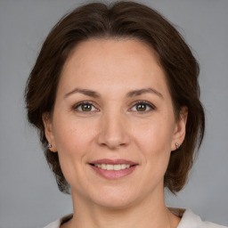 Joyful white adult female with medium  brown hair and brown eyes