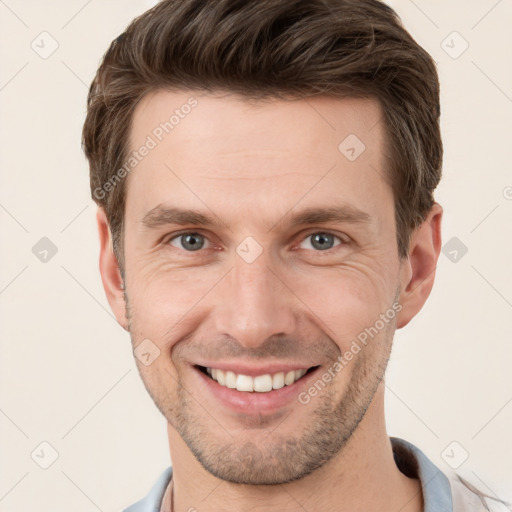 Joyful white young-adult male with short  brown hair and grey eyes