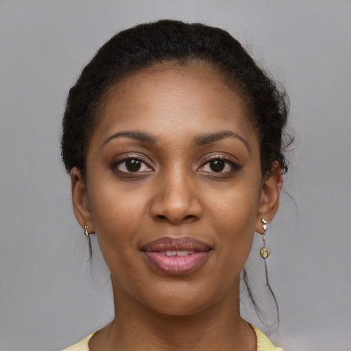 Joyful black young-adult female with long  brown hair and brown eyes