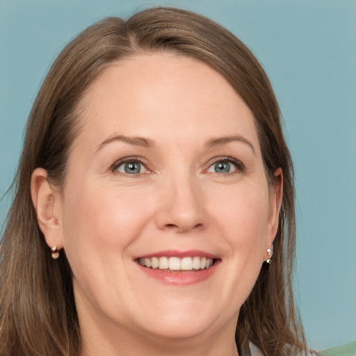 Joyful white adult female with long  brown hair and grey eyes