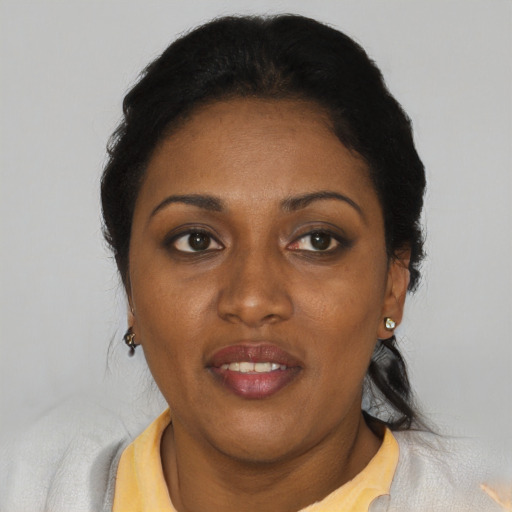 Joyful black adult female with short  black hair and brown eyes