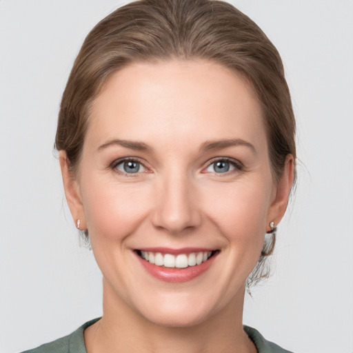 Joyful white young-adult female with medium  brown hair and grey eyes