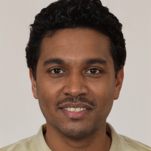 Joyful black young-adult male with short  black hair and brown eyes