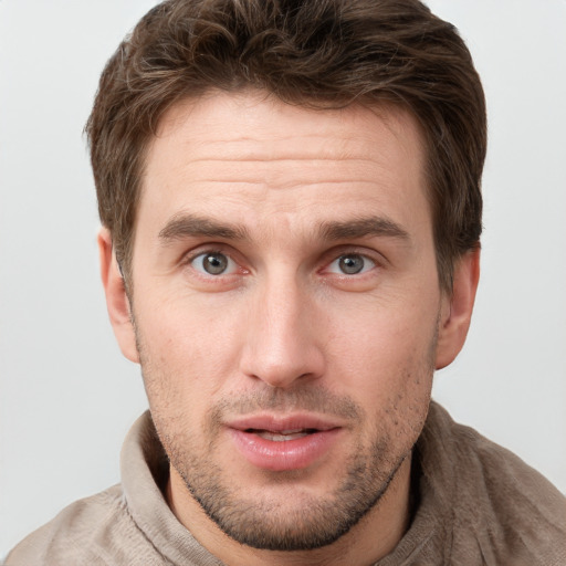 Joyful white young-adult male with short  brown hair and grey eyes