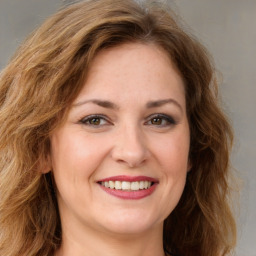 Joyful white young-adult female with long  brown hair and green eyes