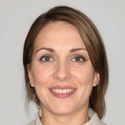 Joyful white adult female with medium  brown hair and brown eyes