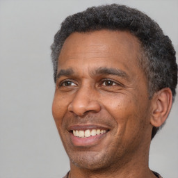 Joyful black adult male with short  black hair and brown eyes