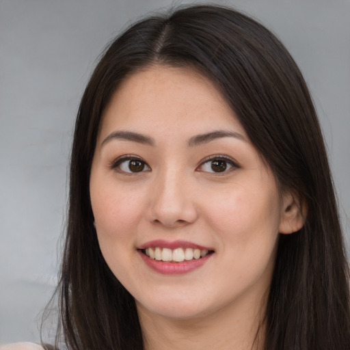 Joyful asian young-adult female with long  brown hair and brown eyes