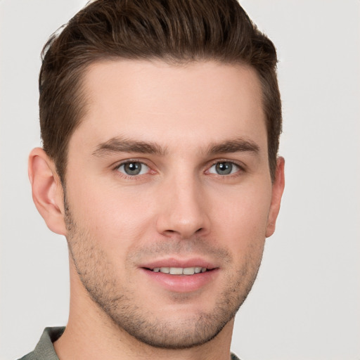 Joyful white young-adult male with short  brown hair and grey eyes