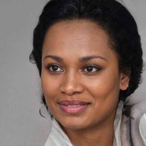 Joyful black young-adult female with long  black hair and brown eyes