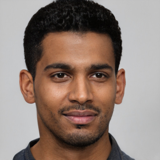 Joyful black young-adult male with short  black hair and brown eyes