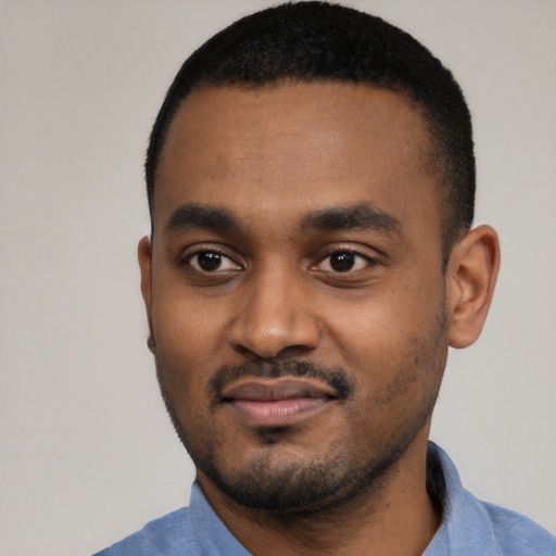 Joyful black young-adult male with short  black hair and brown eyes
